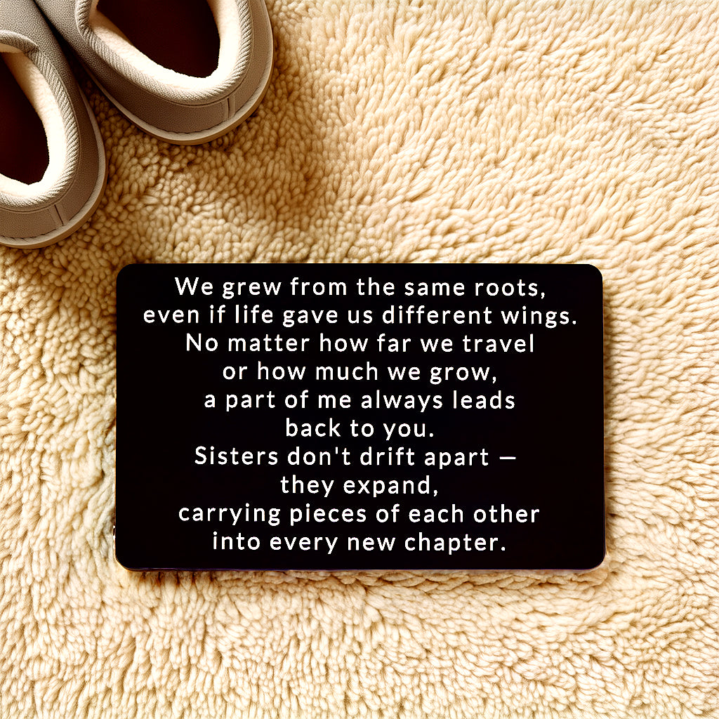 Black engraved metal wallet card reading 'We Grew From the Same Roots' lying on a cream shag rug next to a pair of slippers.